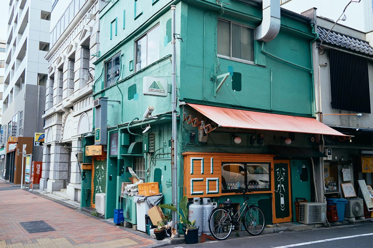 明るいグリーンの建物が目印。
