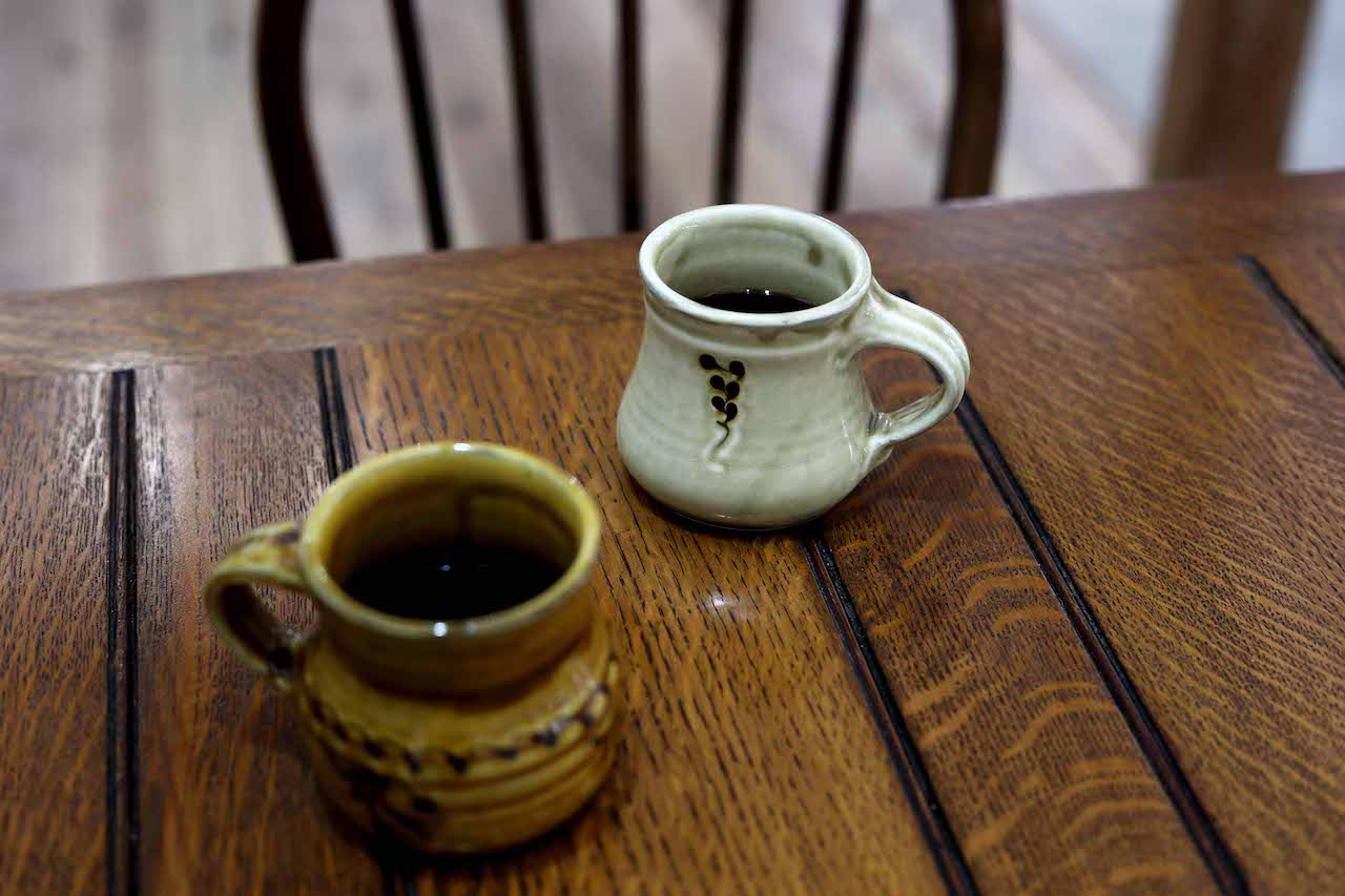 コーヒー（￥550）もとても美味しい。「豆は滋賀県の高島市にある『漕人』さんにお願いしてます」。この日は信楽在住の陶芸作家・山田洋次さんのスリップウェアカップで。